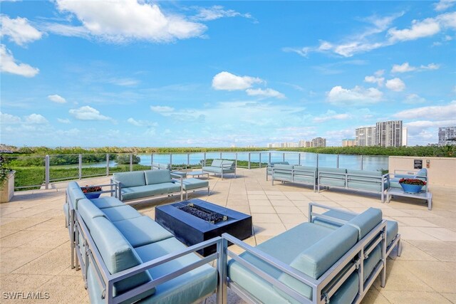 view of patio / terrace with a view of city, a water view, and an outdoor living space with a fire pit