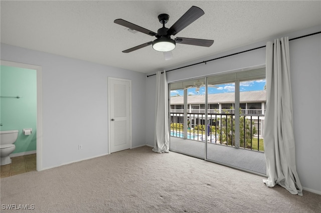 unfurnished bedroom featuring ceiling fan, ensuite bath, light colored carpet, and access to outside