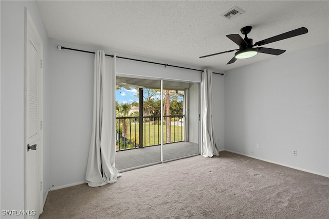 carpeted spare room featuring ceiling fan and a textured ceiling