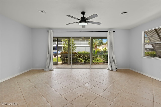 tiled empty room featuring ceiling fan