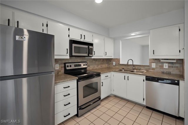 kitchen with sink, backsplash, stainless steel appliances, and white cabinets