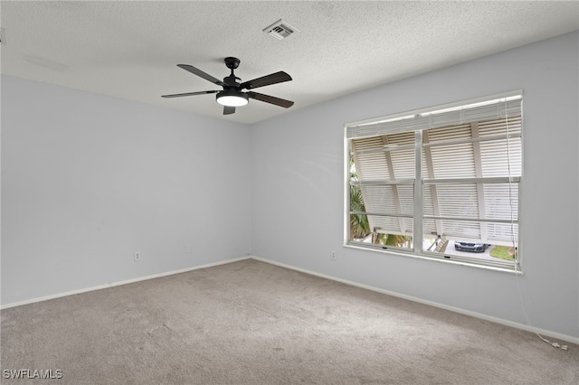 unfurnished room with a textured ceiling, carpet floors, and ceiling fan