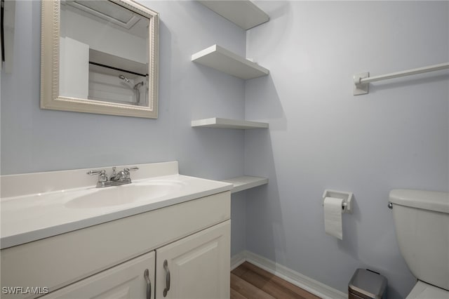 bathroom with vanity, toilet, and wood-type flooring