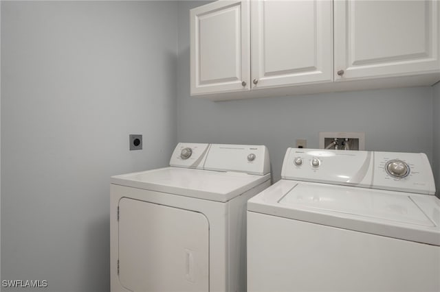 laundry room featuring cabinets and washing machine and dryer