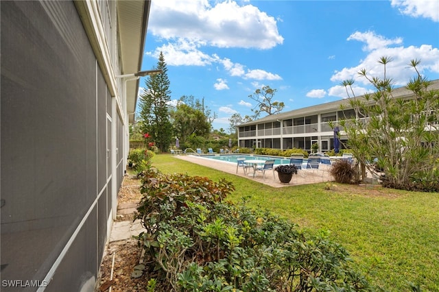 view of swimming pool featuring a patio and a yard