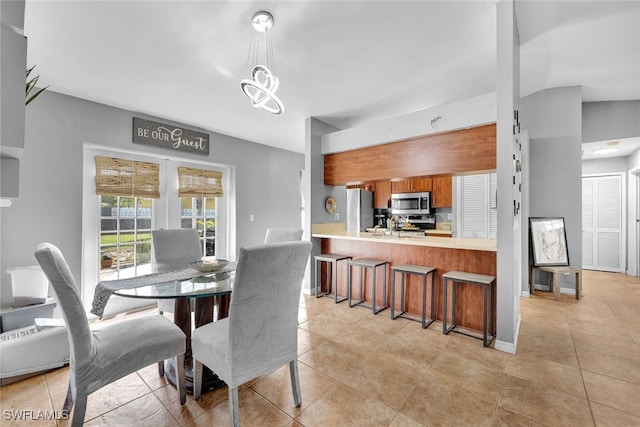 tiled dining room with a chandelier