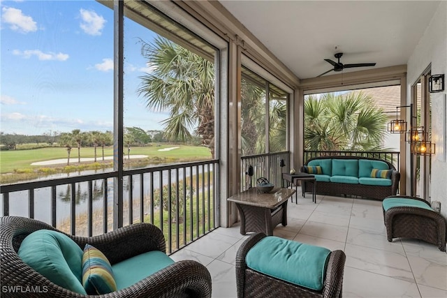 sunroom featuring ceiling fan and a water view