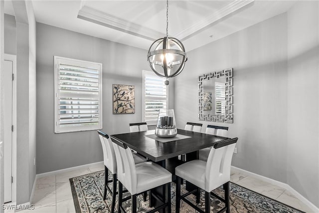 dining area with crown molding, a tray ceiling, and a chandelier