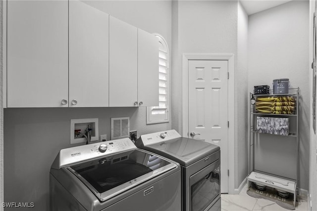 washroom featuring washer and dryer and cabinets