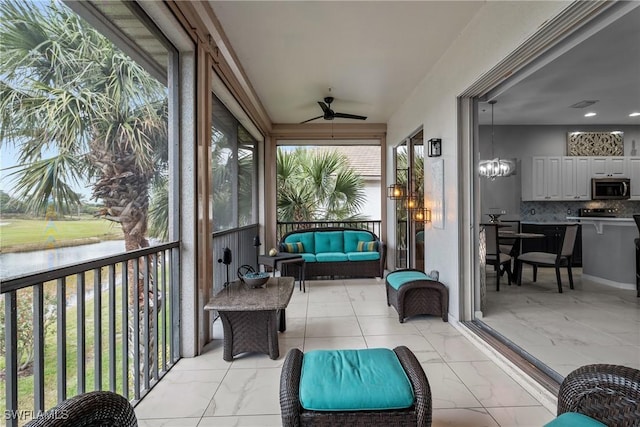 sunroom with ceiling fan and a water view