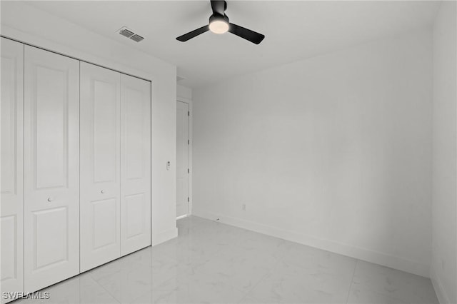 unfurnished bedroom featuring ceiling fan and a closet