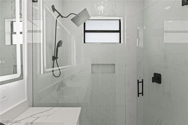 bathroom with a shower with door