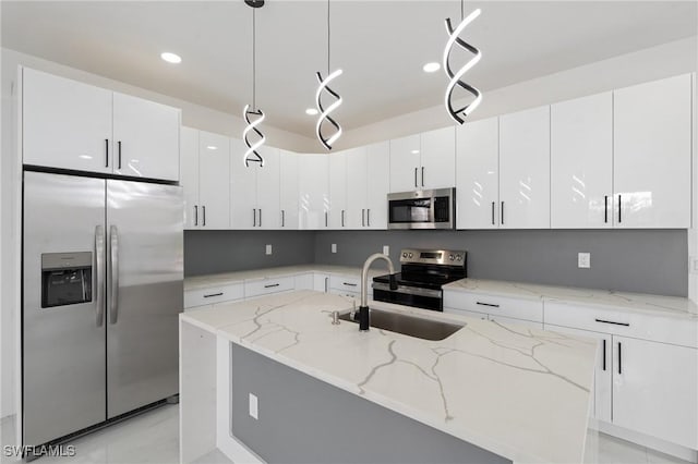 kitchen featuring pendant lighting, light stone countertops, white cabinetry, and stainless steel appliances