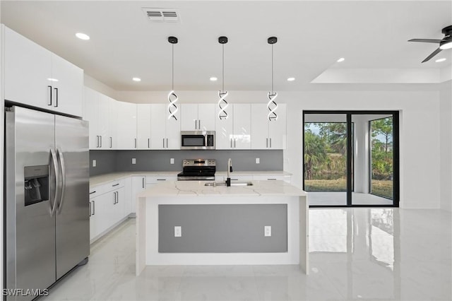 kitchen featuring white cabinetry, sink, decorative light fixtures, and stainless steel appliances