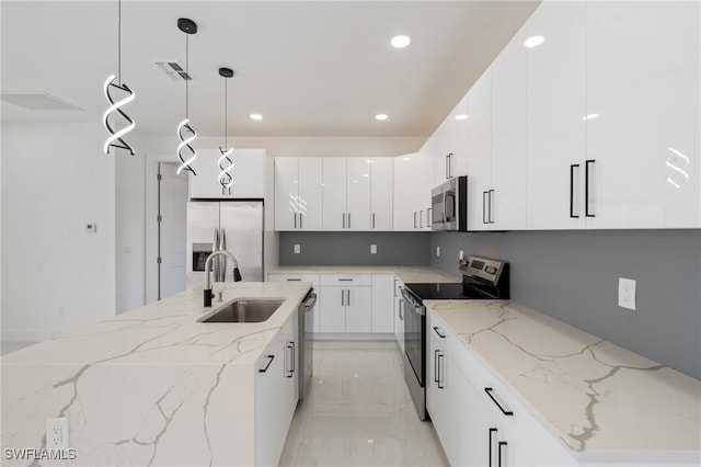 kitchen featuring pendant lighting, white cabinetry, sink, stainless steel appliances, and light stone countertops