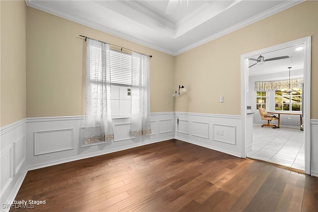 spare room featuring wood-type flooring, a wealth of natural light, and ornamental molding