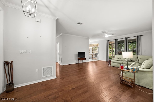 living room with dark hardwood / wood-style floors, an inviting chandelier, and ornamental molding