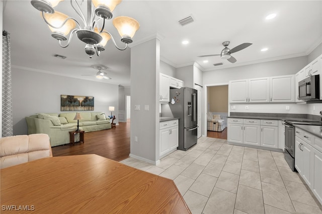 kitchen featuring white cabinets, ornamental molding, and stainless steel appliances