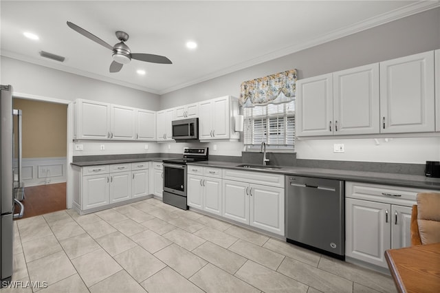 kitchen featuring white cabinets, stainless steel appliances, sink, ornamental molding, and ceiling fan