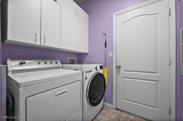 clothes washing area with light tile patterned floors, independent washer and dryer, and cabinets