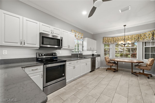 kitchen featuring decorative light fixtures, appliances with stainless steel finishes, ceiling fan with notable chandelier, and white cabinetry