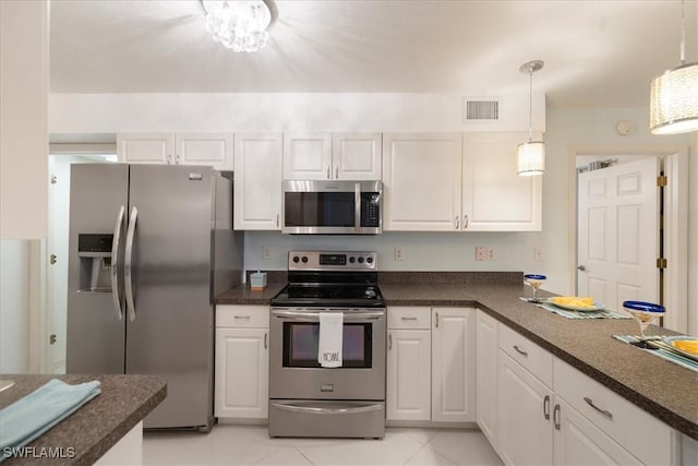 kitchen featuring hanging light fixtures, light tile patterned floors, stainless steel appliances, and white cabinetry