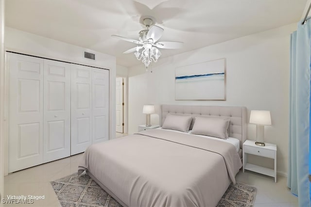 bedroom featuring ceiling fan, light tile patterned floors, and a closet