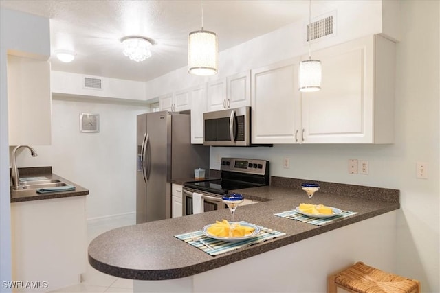 kitchen featuring sink, kitchen peninsula, white cabinets, and stainless steel appliances