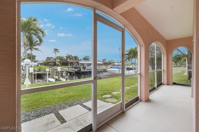 unfurnished sunroom featuring a water view