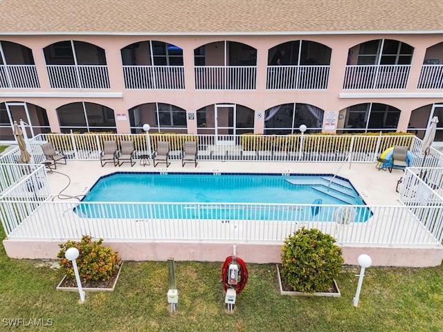 view of swimming pool with a patio area and a lawn