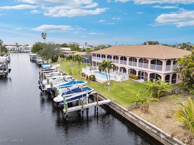 view of dock featuring a water view, a pool, and a lawn