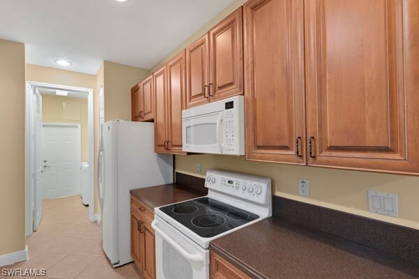 kitchen featuring white appliances and light tile patterned flooring