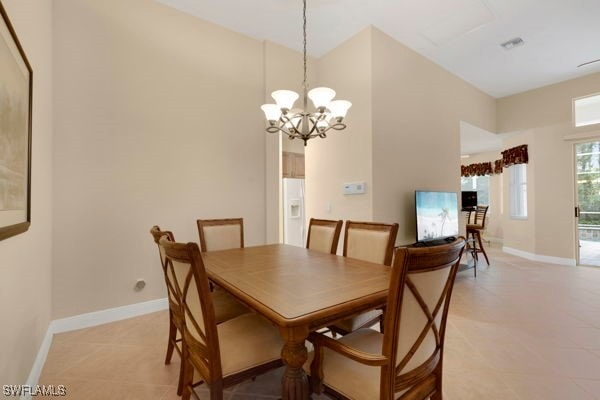 tiled dining room with a chandelier