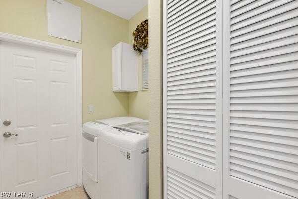 laundry room featuring cabinets and washer and clothes dryer