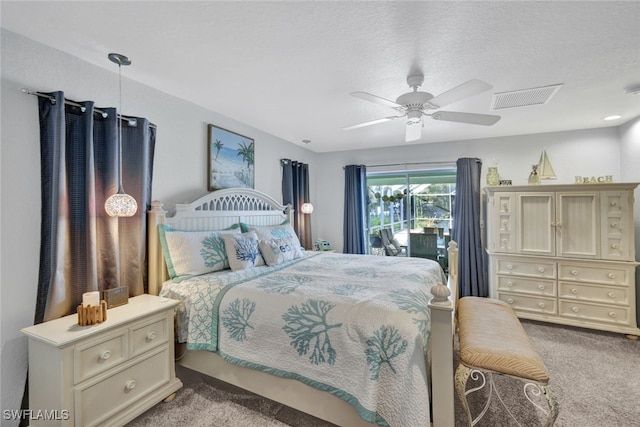 carpeted bedroom with ceiling fan and a textured ceiling