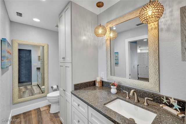 bathroom featuring vanity, wood-type flooring, and toilet