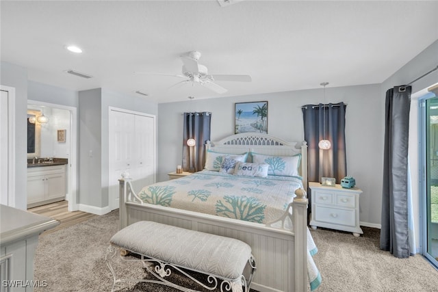 bedroom featuring multiple windows, ceiling fan, ensuite bath, and a closet