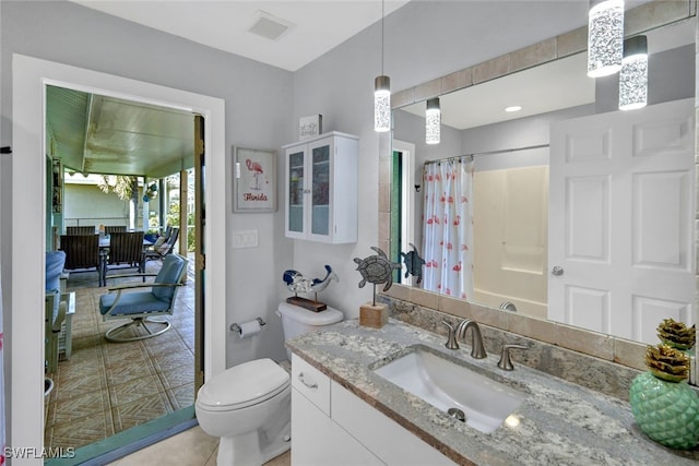 bathroom featuring vanity, tile patterned flooring, and toilet