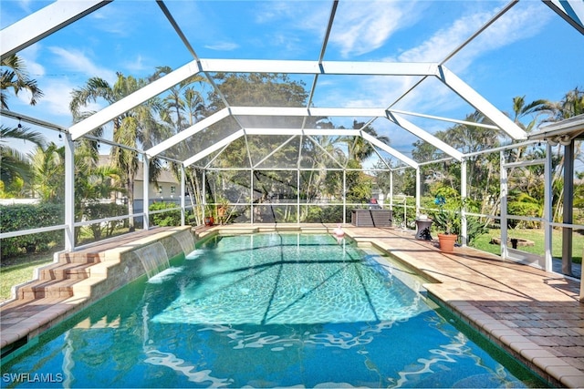 view of pool with pool water feature, a lanai, and a patio area