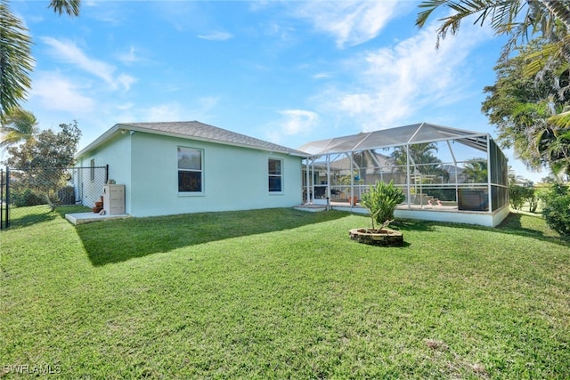 rear view of property with a yard and a lanai