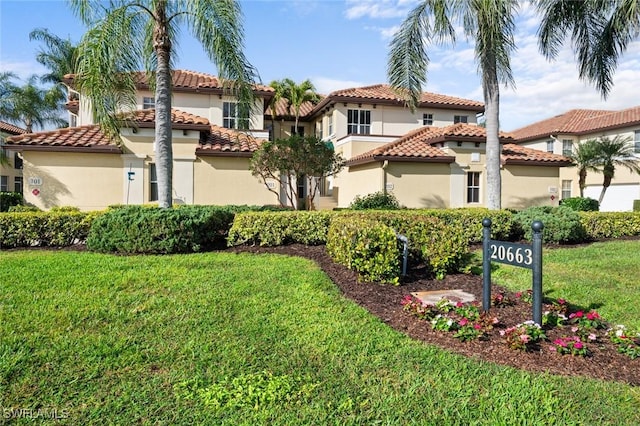 mediterranean / spanish home with a front lawn