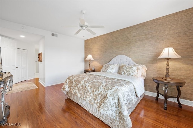 bedroom with wood-type flooring, ceiling fan, and a closet