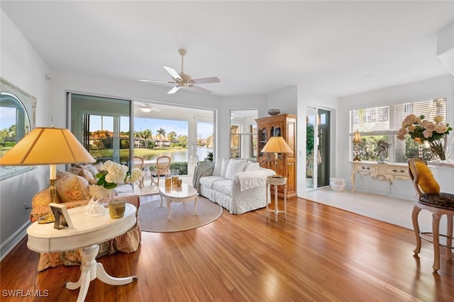 living room with a water view and light hardwood / wood-style flooring