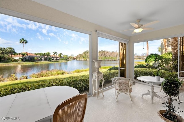 sunroom / solarium featuring a water view and ceiling fan