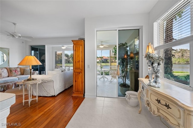 doorway with light tile patterned flooring and ceiling fan