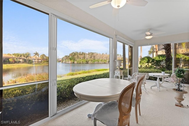 sunroom / solarium featuring ceiling fan and a water view