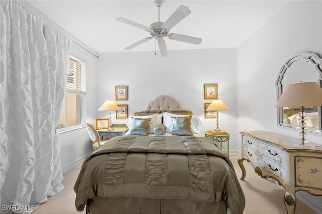 bedroom featuring multiple windows, ceiling fan, and light carpet