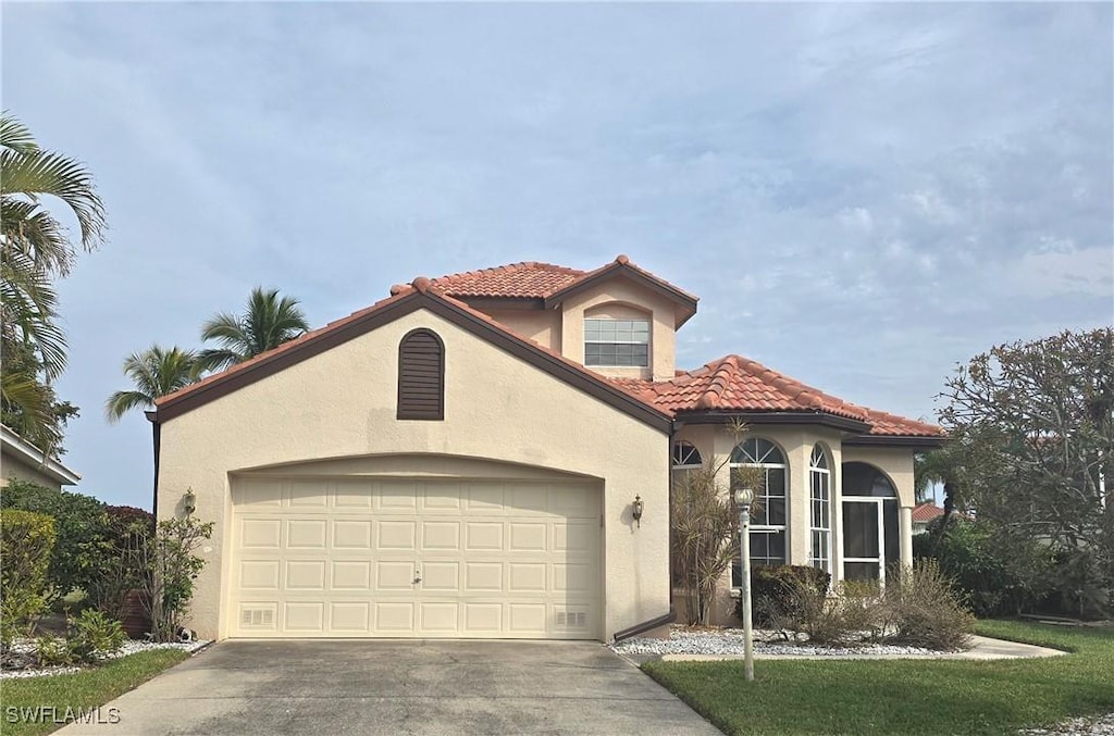 mediterranean / spanish-style house with a garage