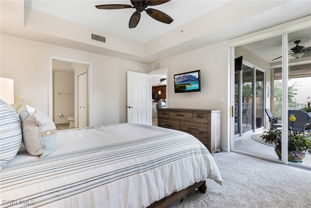 bedroom with ceiling fan, access to exterior, ensuite bath, a tray ceiling, and carpet flooring