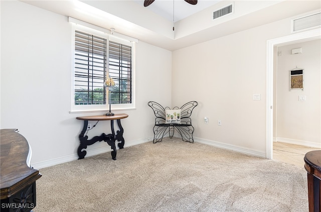 sitting room with ceiling fan and light colored carpet